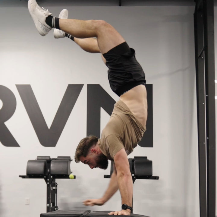 Athlete performing a handstand walk on soft boxes wearing black FLX Pro Shorts.