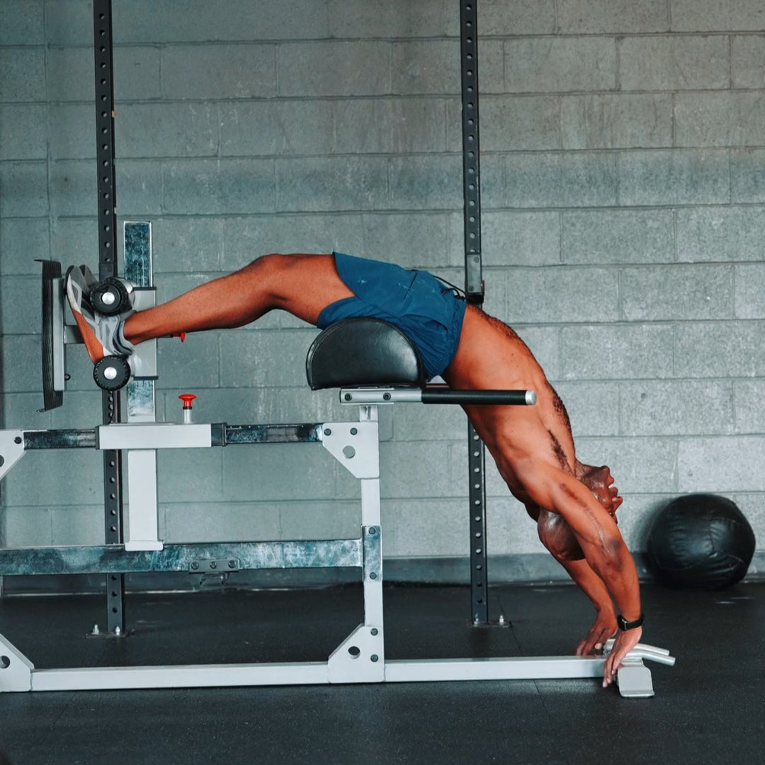 Athlete holding a back extension on GHD machine, stretching in blue FLX Pro Shorts.