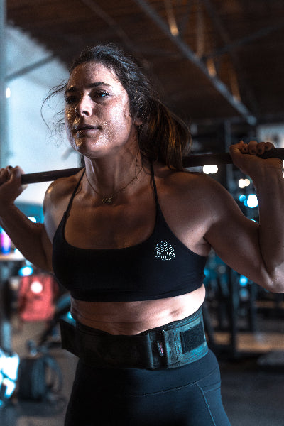 Woman lifting a barbell in a gym setting
