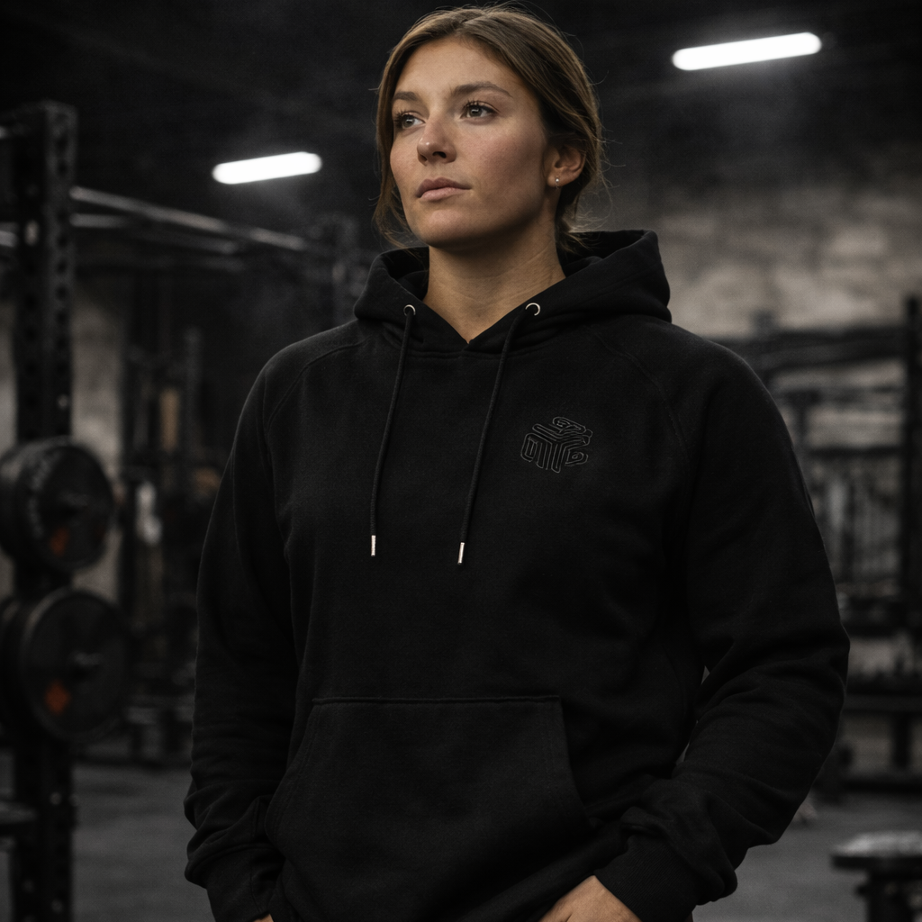 Female wearing a black hoodie in a gym setting.