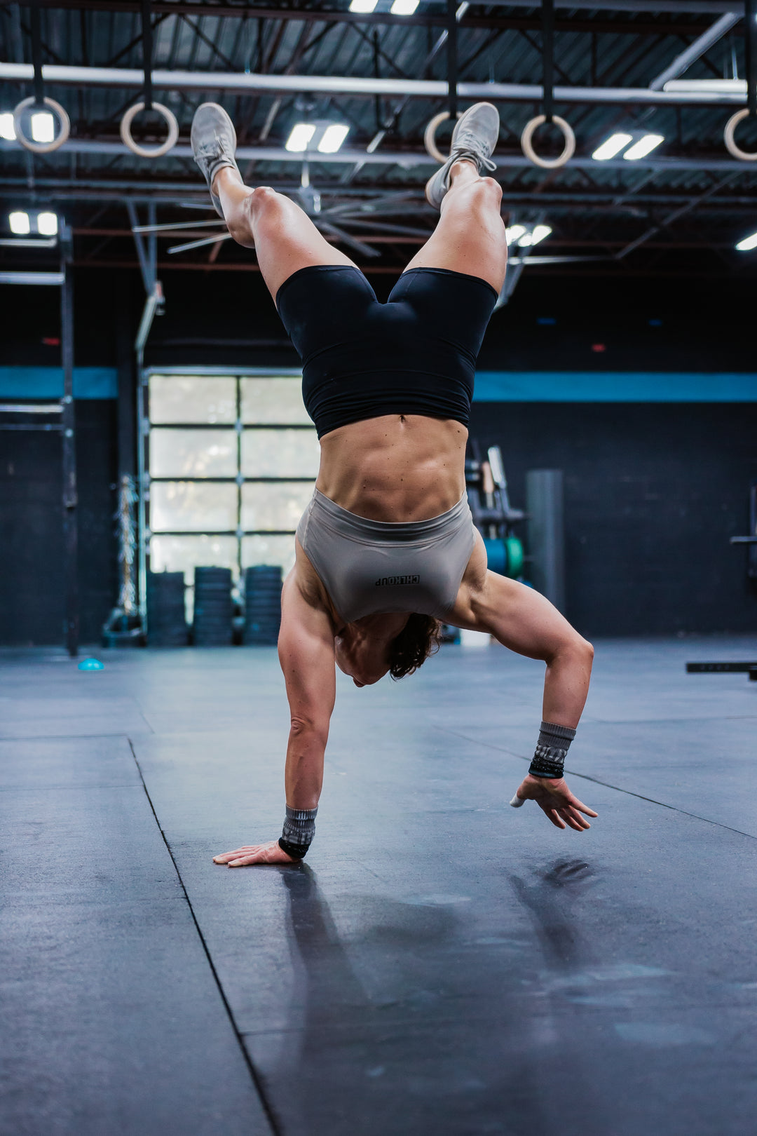 Person performing a handstand in a gym setting